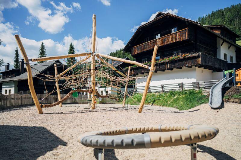 Huettendorf-Feriendorf-Oesterreich-Urlaub-mit-Kind-Skiurlaub-Ferienwohnung-Kaernten-Slow-Travel-Resort-Kirchleitn-nachhaltig-Spielplatz