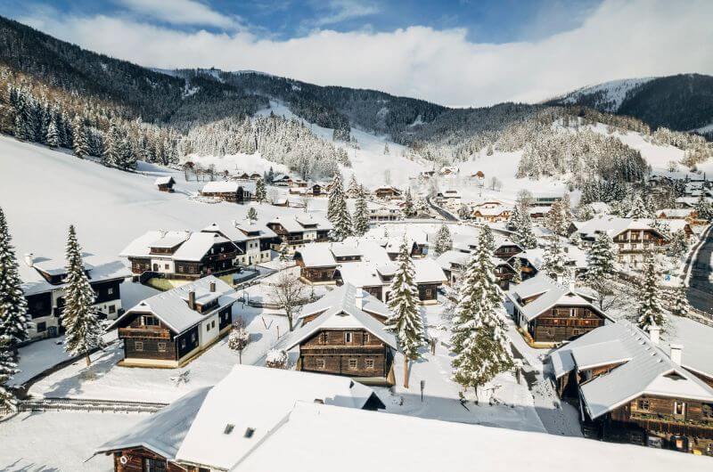 Huettendorf-Feriendorf-Oesterreich-Urlaub-mit-Kind-Skiurlaub-Ferienwohnung-Kaernten-Slow-Travel-Resort-Kirchleitn-nachhaltig-Winter-Schnee