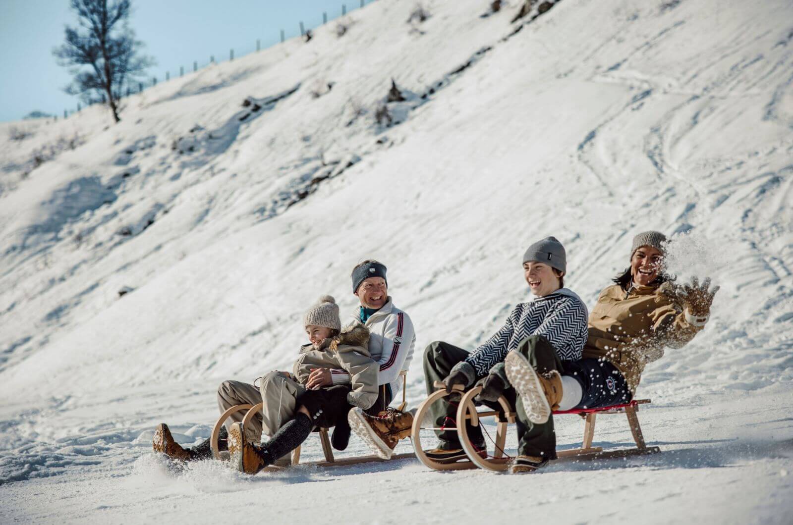 Schlitten-fahren-rodeln-Familienhotel-direkt-an-Skipiste-Saalbach-Hinterglemm-Urlaub-mit-Kind-Pool-Kids-Club-Skischule-Hotel-Theresia