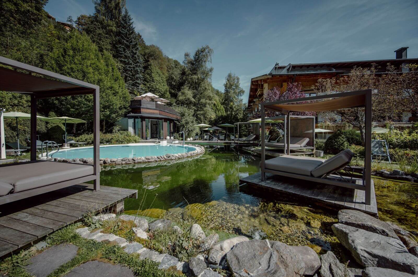 Schwimmteich-Daybed-Familienhotel-4-Sterne-Superior-Hinterglemm-Urlaub-mit-Kind-Pool-Waldgarten-Hotel-Theresia